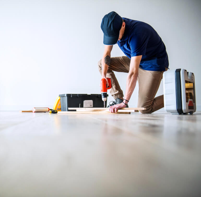 Installer fastening hardwood flooring planks