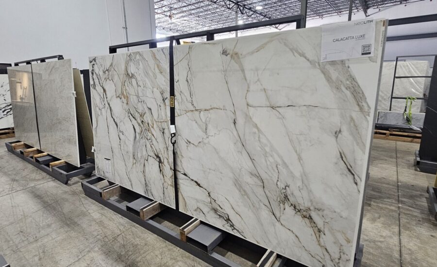 Full-size quartz and porcelain slabs with marble veining in a stone supplier's warehouse