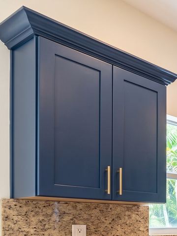Navy shaker wall cabinet with brushed brass bar pulls