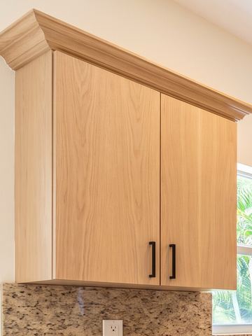 Light oak slab wall cabinet with matte black bar pulls
