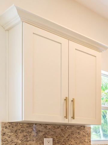 Warm white shaker wall cabinet with brushed brass bar pulls