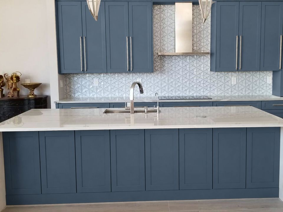 After, visualization: the same kitchen with Aria Blue shaker cabinets; countertops, backsplash and hood unchanged